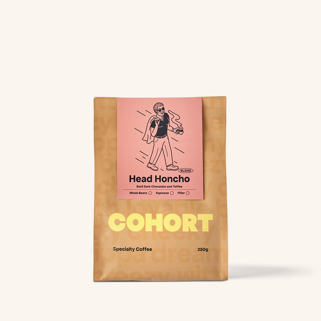 A packaged coffee beans labeled 'Head Honcho' by Cohort Coffee, featuring an illustration of a character on the front.