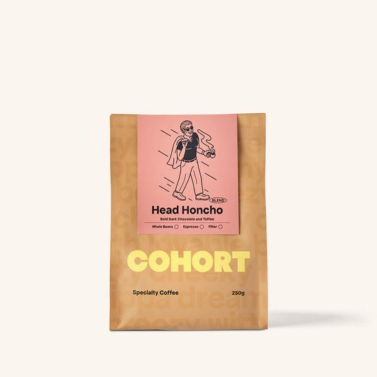 A packaged coffee beans labeled 'Head Honcho' by Cohort Coffee, featuring an illustration of a character on the front.